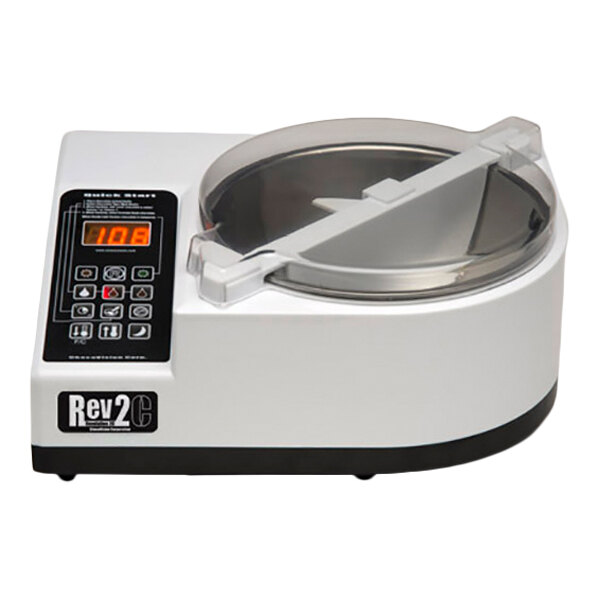 A white countertop machine with a digital control panel and a transparent lid covering a circular metal bowl.
