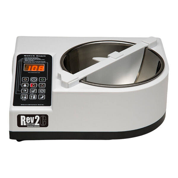 A white electronic device with a digital display, control panel, and a stainless steel bowl, likely used for food preparation.
