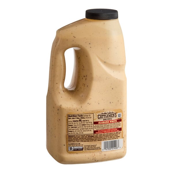 A large plastic jug filled with a creamy, speckled sauce and a black screw-on cap, featuring a label with nutritional information and product details.