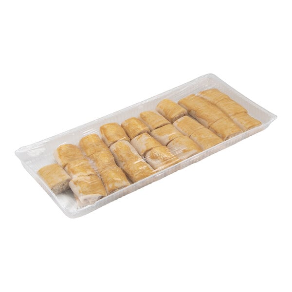 A plastic tray containing several small, golden-brown croissant pieces wrapped in clear plastic.