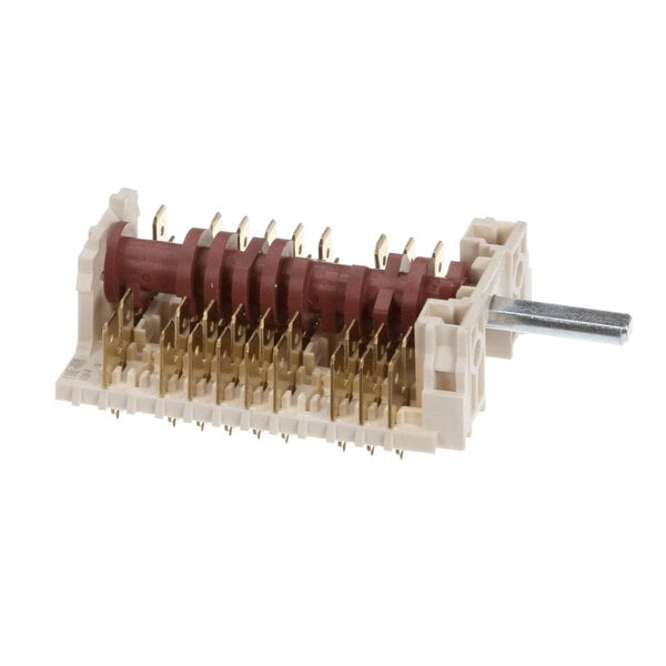 A rotary switch component with multiple gold-colored terminals, a red central shaft, and a protruding metal rod, mounted on a beige plastic base.