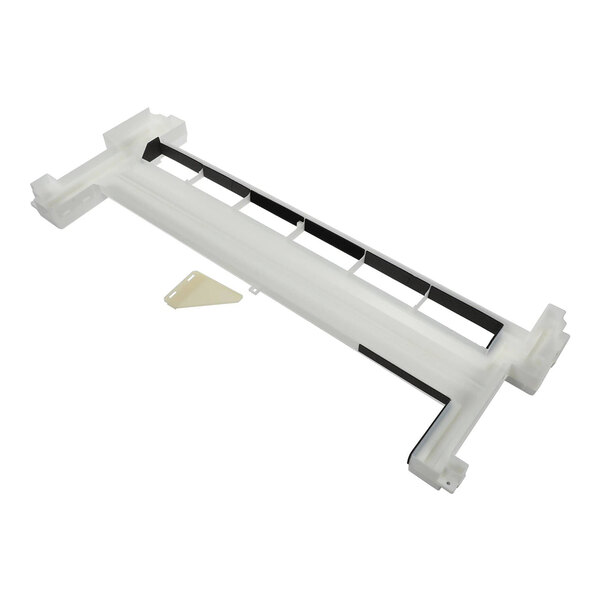 A white, rectangular plastic component with black accents and a small beige triangular piece beside it, likely a part of an appliance or machinery.