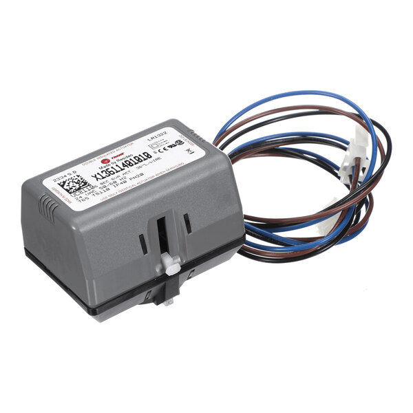 A gray rectangular electronic device with a label on top and several attached wires ending in a white connector.