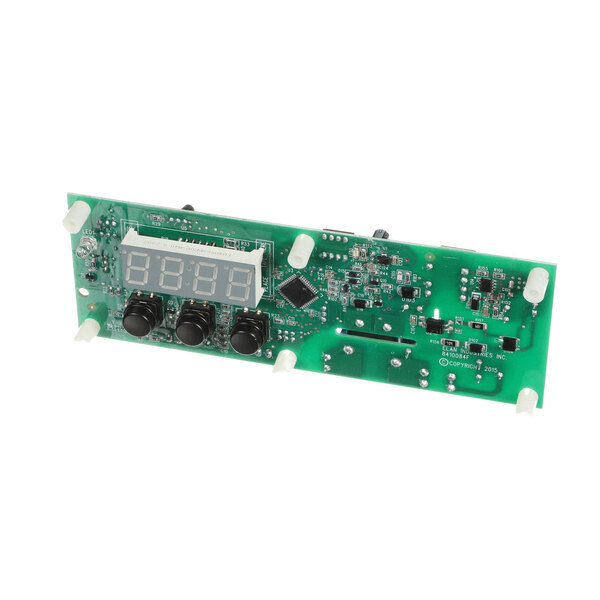 A green electronic control board featuring a digital display, three black control knobs, and various electronic components mounted on the surface.