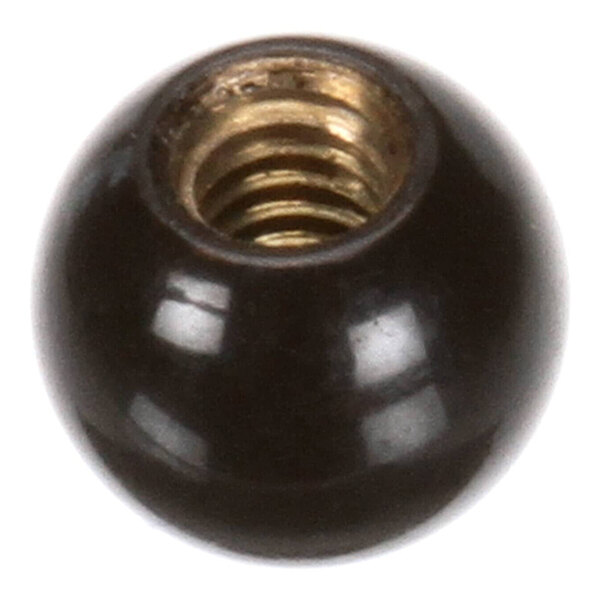 A close-up view of a shiny black spherical object with a brass threaded insert.