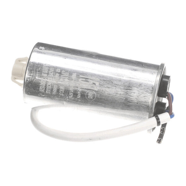 A cylindrical metallic component with attached wires, likely an electrical capacitor.