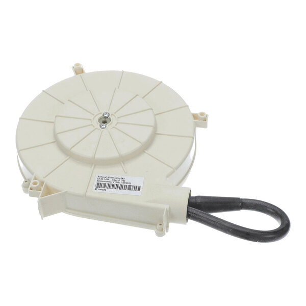 A round, beige plastic component with a central screw, mounting points, and a black flexible looped hose attached.
