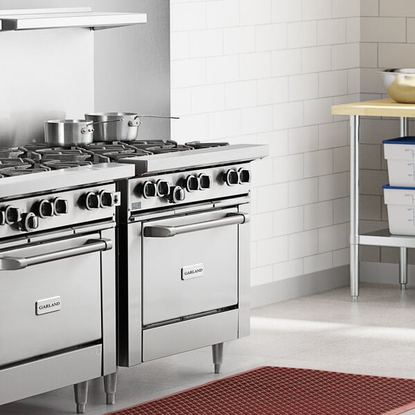A commercial stainless steel 6-burner range with an oven, designed for professional kitchens.