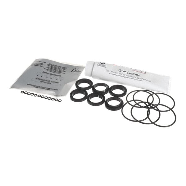 A set of black rubber-like O-rings and seals, a tube of grease, and a packet, all arranged on a white surface.