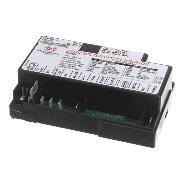 A rectangular black electronic module with multiple metal prongs and a white label on top displaying technical information and wiring instructions.