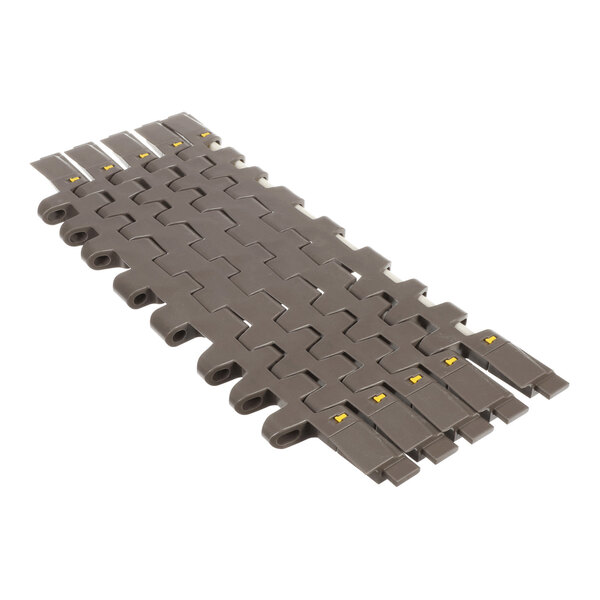 A section of interlocking, brown plastic conveyor belt links with a flat, segmented surface and small yellow markings.