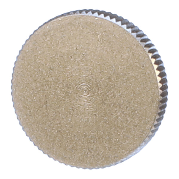 A round, metallic, textured object with a knurled edge, viewed from above.
