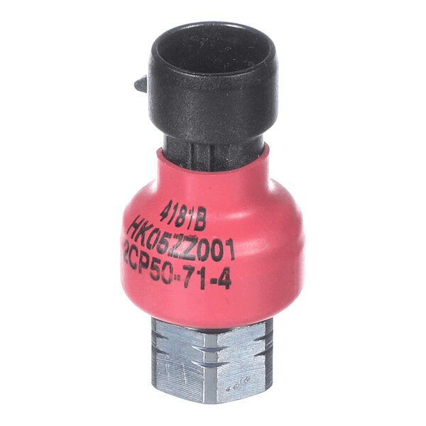 A small cylindrical electronic component with a black top connector, a red middle section with printed text, and a metallic hexagonal base.