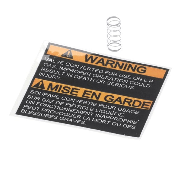 A small metal coil spring and a bilingual warning label, with English and French text, are shown on a white background.