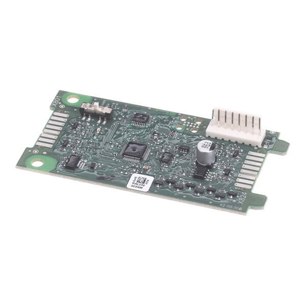 A green printed circuit board with various electronic components, including integrated circuits, a capacitor, and a white connector.