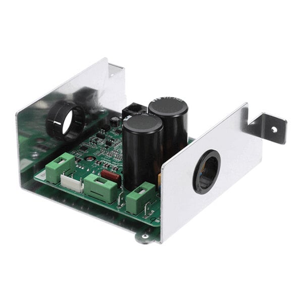 An electronic circuit board with several capacitors, connectors, and a partially enclosed metal casing featuring circular cutouts.