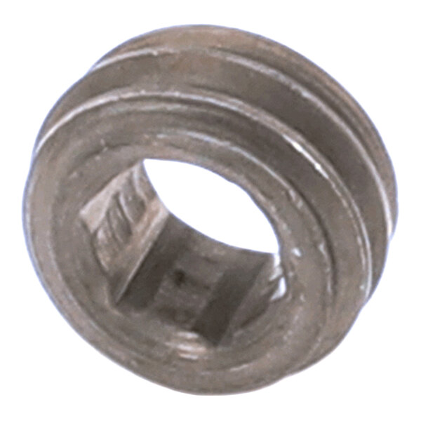 A close-up view of a small, metallic, circular component with a hollow center and spiral grooves on its outer surface.