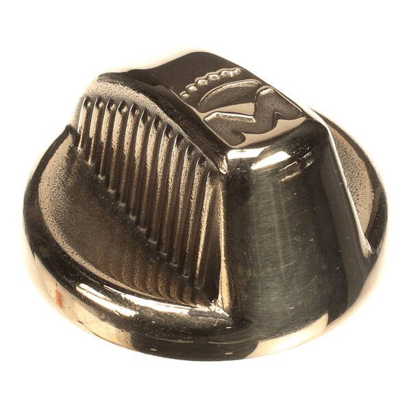 A metallic, round, ridged control knob with a shiny brass-like finish and a raised symbol on top.