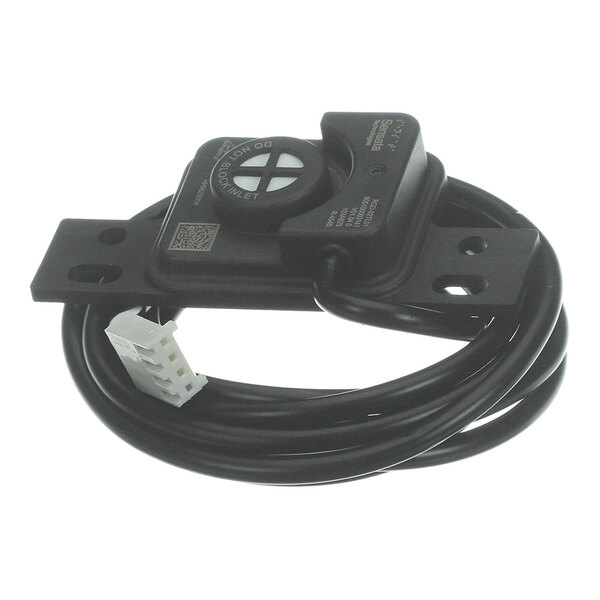 A black electronic sensor with a circular component, attached to a mounting bracket and a coiled cable ending in a white connector.