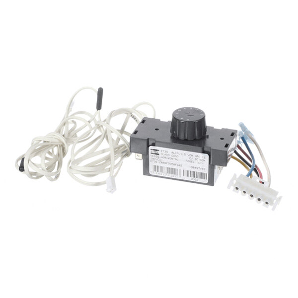 A black electronic controller unit with a rotary knob, attached to several wires and connectors, and a long white cable with sensors.