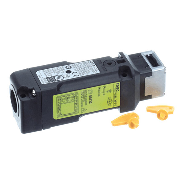 A rectangular black and silver electrical switch component with yellow labels and two small yellow plastic pieces beside it.