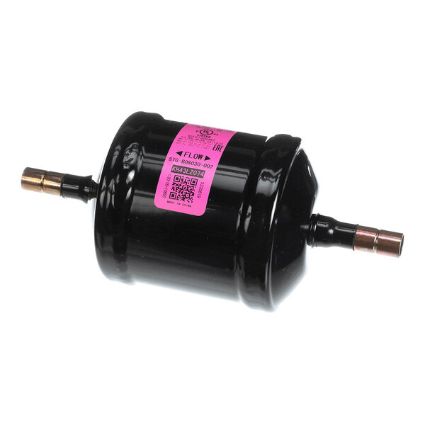 A cylindrical black metal component with copper fittings on both ends and a pink label in the center.
