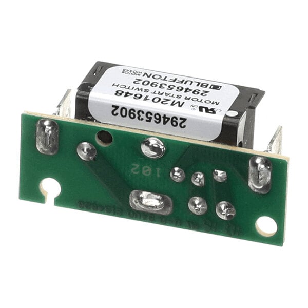 A small electronic component with a green circuit board and a black rectangular module attached, featuring several soldered connections and a white label with text.