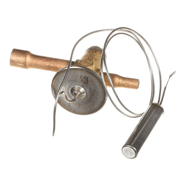 A brass and metal valve component with attached coiled tubing and a cylindrical sensor or probe.