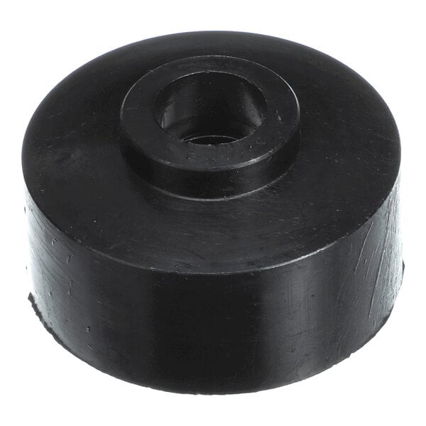 A black, cylindrical object with a central hole, resembling a molded plastic or rubber washer or spacer.