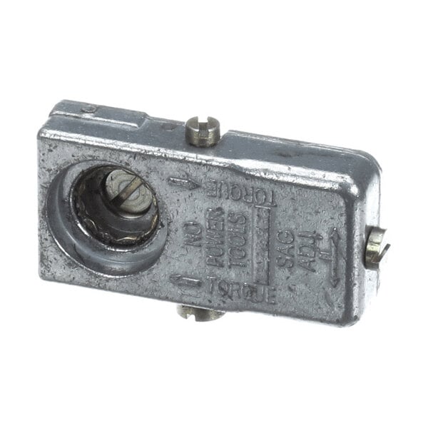 A rectangular metallic component with a circular opening, visible screw, and engraved text on its surface.