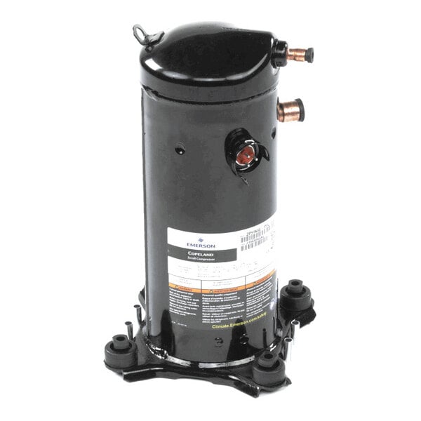 A black cylindrical mechanical component with copper pipe fittings and a label, mounted on a base with four feet.