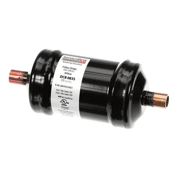 A cylindrical black metal component with copper pipe fittings on both ends and a white label in the center.