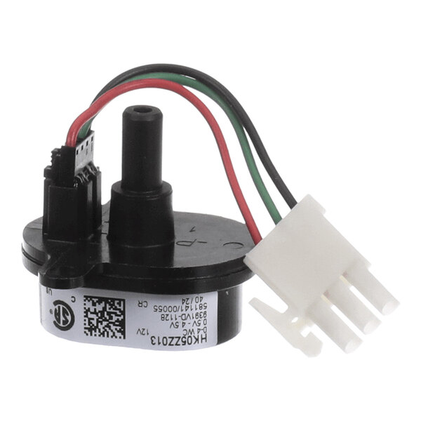 A small electronic component with three colored wires (red, green, and black) connected to a white plastic connector and a cylindrical black housing.