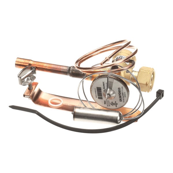 A collection of metal and copper components, including coiled tubing, a cylindrical part, a bracket, and a plastic zip tie, arranged together on a white background.