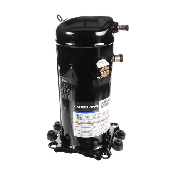 A black cylindrical mechanical component with copper pipe fittings and a label, mounted on a base with four rubber feet.