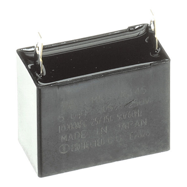 A rectangular black electronic component with two metal prongs extending from the top, likely a capacitor.