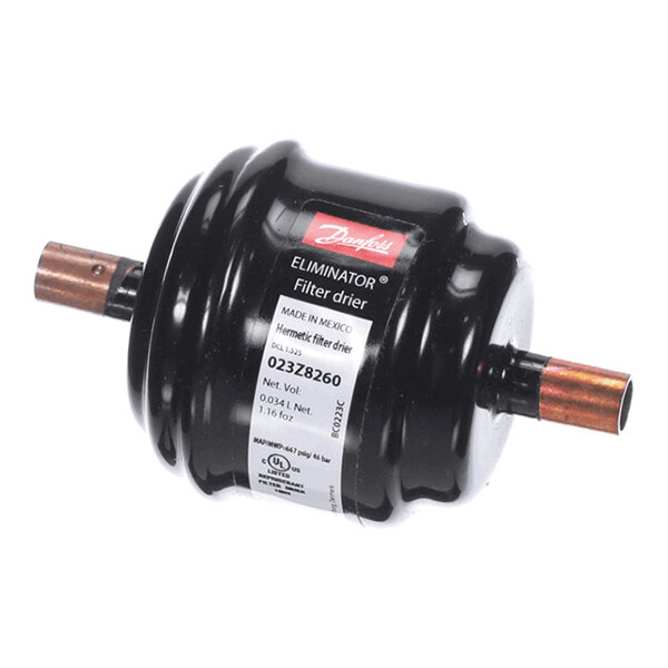 A cylindrical black filter drier with copper pipe connections on both ends and a label indicating product details.