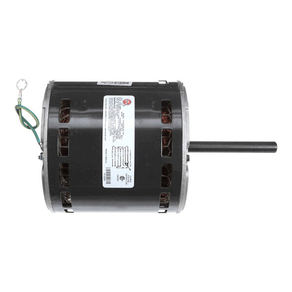 A cylindrical electric motor with a black housing, visible copper windings through ventilation slots, a protruding shaft on one side, and a green grounding wire attached.