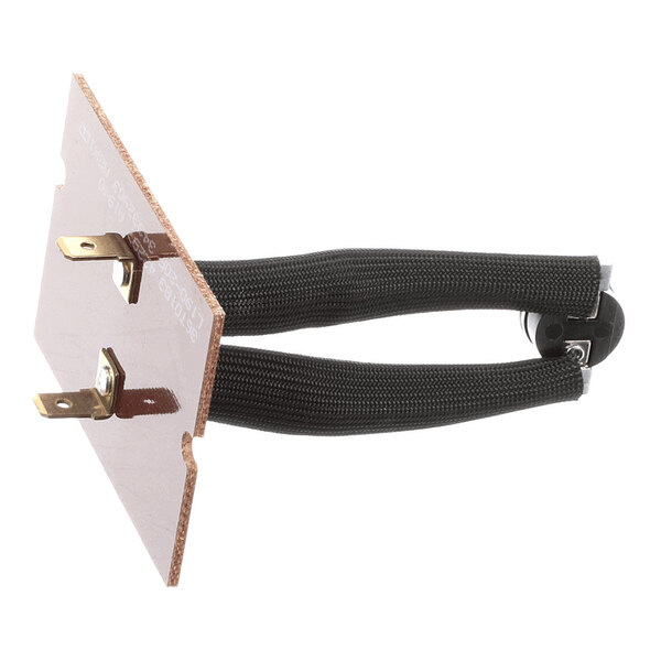 A rectangular component with two metal prongs, a brown board, and two black insulated wires attached to a circular element.