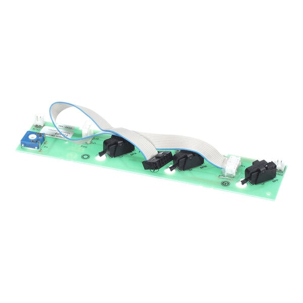 A green electronic control board with several black switches, connectors, and a ribbon cable attached.