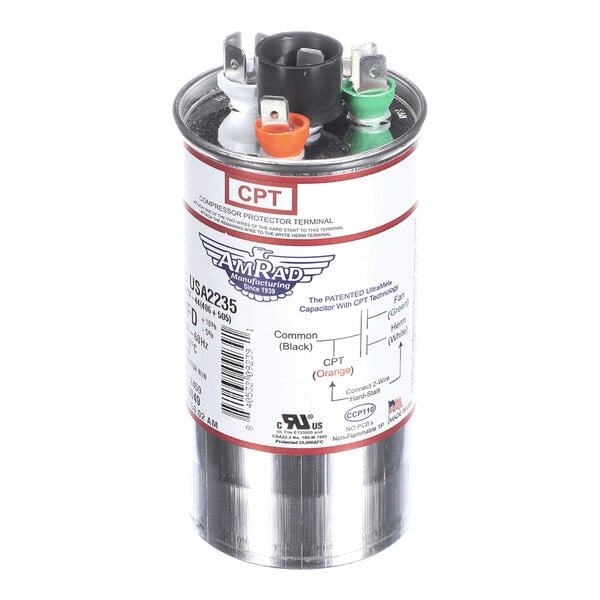 A cylindrical metallic capacitor with labeled terminals in black, orange, white, and green, and a detailed product label on the side.