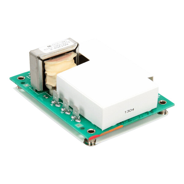 An electronic circuit board with a white rectangular component and a metal-wrapped coil mounted on a green base.