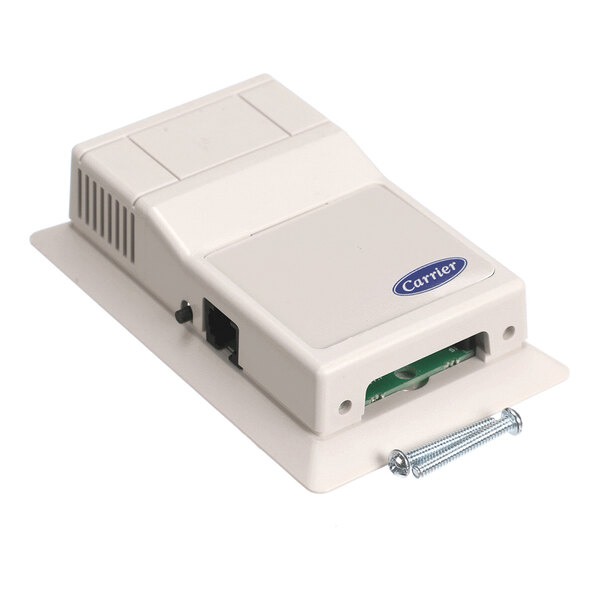 A beige rectangular electronic device with a Carrier logo, ventilation slots, ports, and two screws placed beside it.