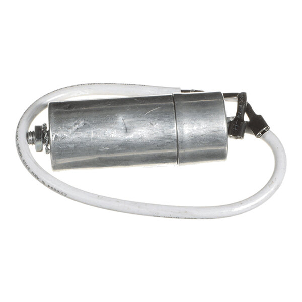 A cylindrical metallic component with a white wire attached, likely an electrical capacitor.