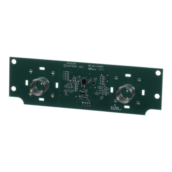 A rectangular green circuit board with various electronic components, including two prominent coiled wires and multiple small surface-mounted parts.