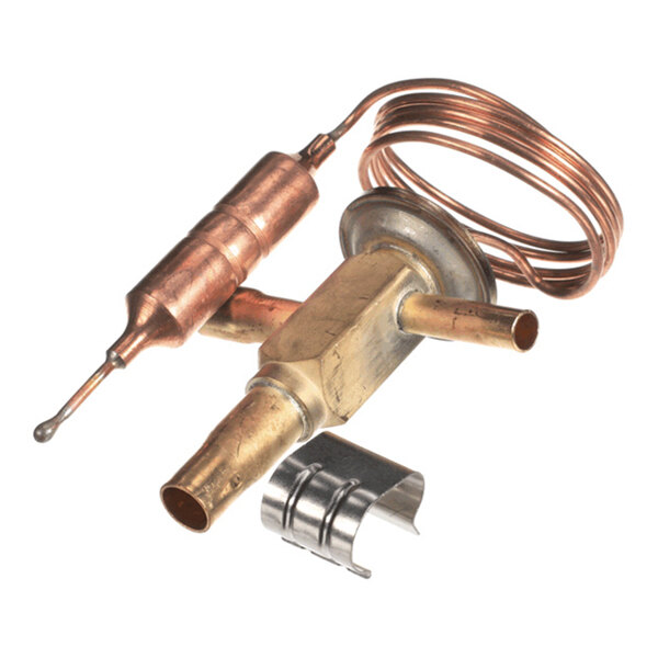 A metallic component with copper tubing, a coiled wire, and a small metal clip, likely part of a refrigeration or HVAC system.
