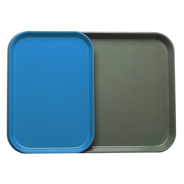 Two blue rectangular Cambro trays with a green insert on a counter.