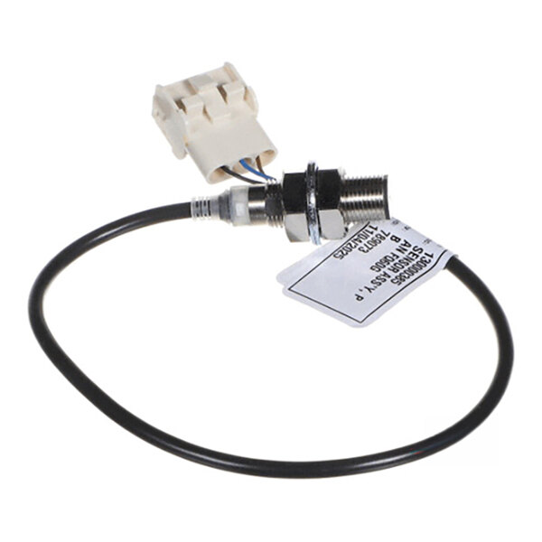 A small electronic sensor with a threaded metal body, attached to a black cable and a white plastic connector, with a label attached to the cable.