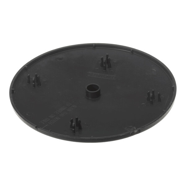 A round, black plastic cover with a central hole and several small raised structures on its surface.