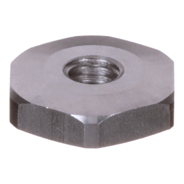 A close-up view of a metallic, hexagonal nut with a central threaded hole.